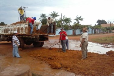 Servidores tapam buraco com enxadas, pás e piçarra