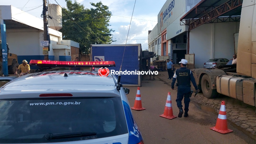 ASSISTA: Asfalto cede e baú de carreta tomba em frente de empresa na capital