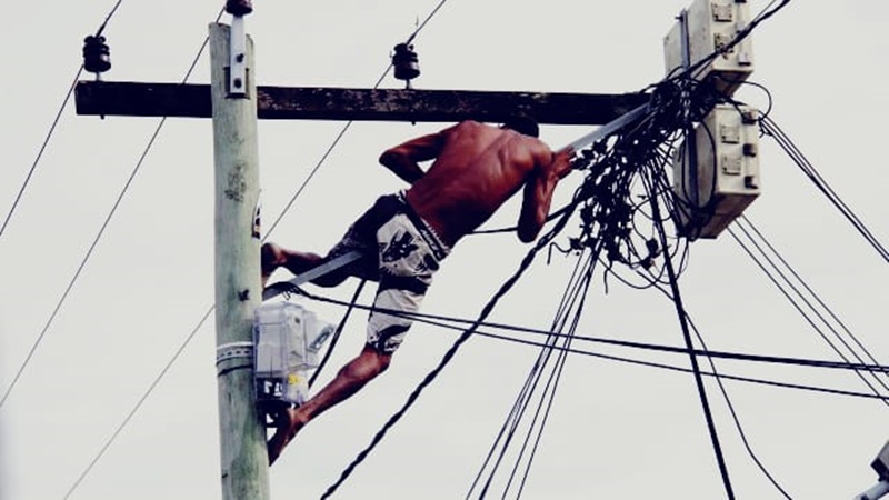 TEM MEDO: Ladrão de fios se pendura em poste após ser surrado por populares