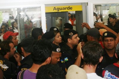 BARRACO – Policial agride vigilantes por ficar travado em porta giratória de banco
