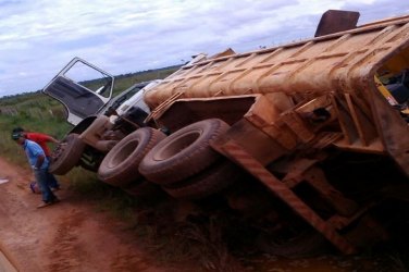 Caminhão da Semosp carregado com trator tomba na área rural