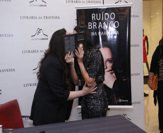 Ana Carolina e Letícia Lima escondem beijo em lançamento de livro