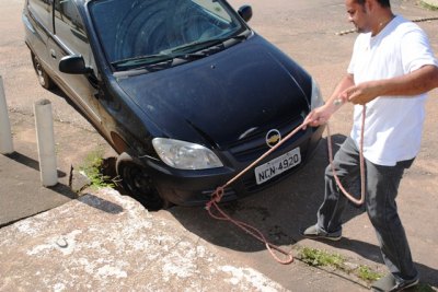 CENA DA CIDADE - Carro fica preso em buraco no Centro de Porto Velho